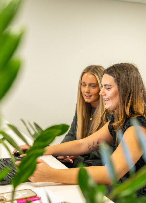 Medium shot of two Exubia female designers within a contemporary workplace environment.