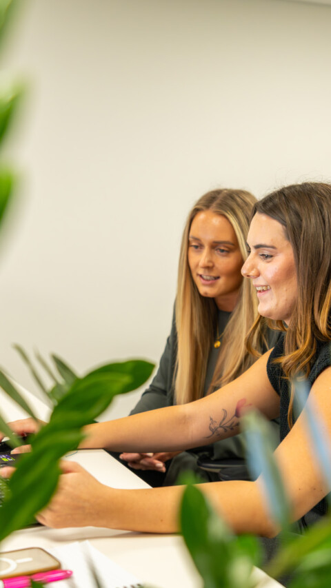 Medium shot of two Exubia female designers within a contemporary workplace environment.