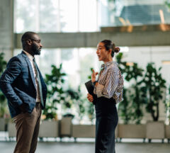 Businesspeople Talking In Modern Office Building Lobby