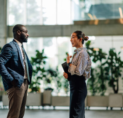 Businesspeople Talking In Modern Office Building Lobby