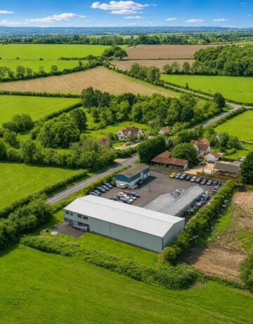 Drone view of the Exubia nursery site on a sunny day surrounded by greenery and open countryside.